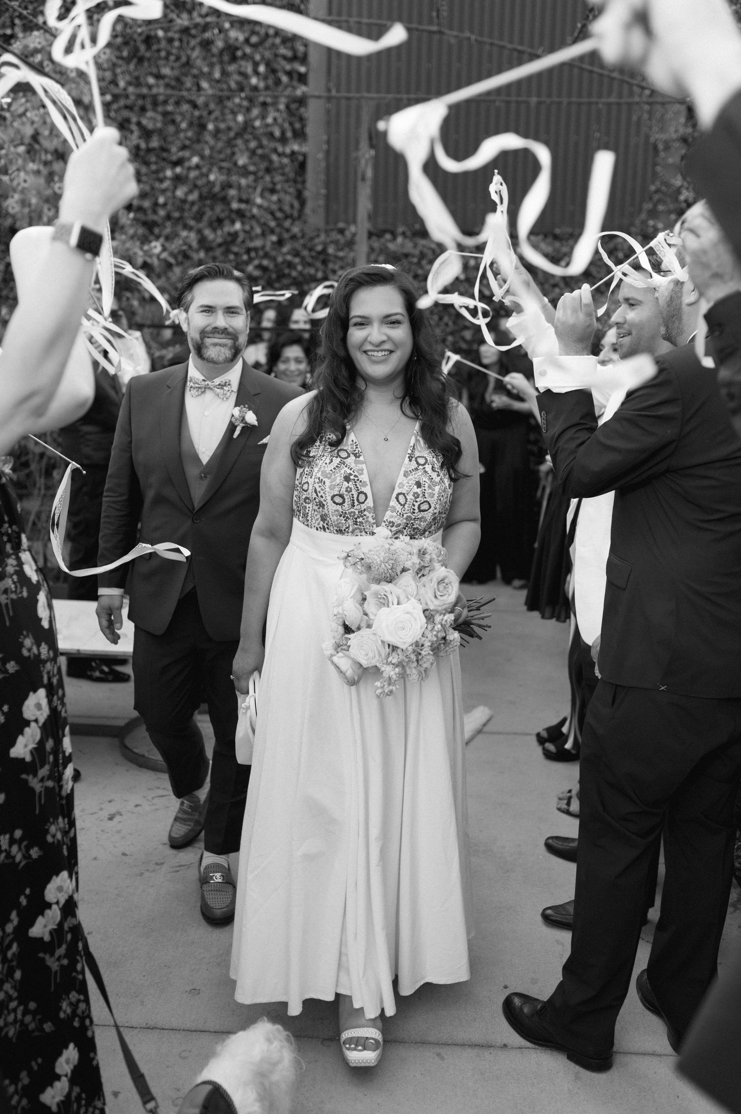 Wedding party walking through sparkler exit celebration in black and white.