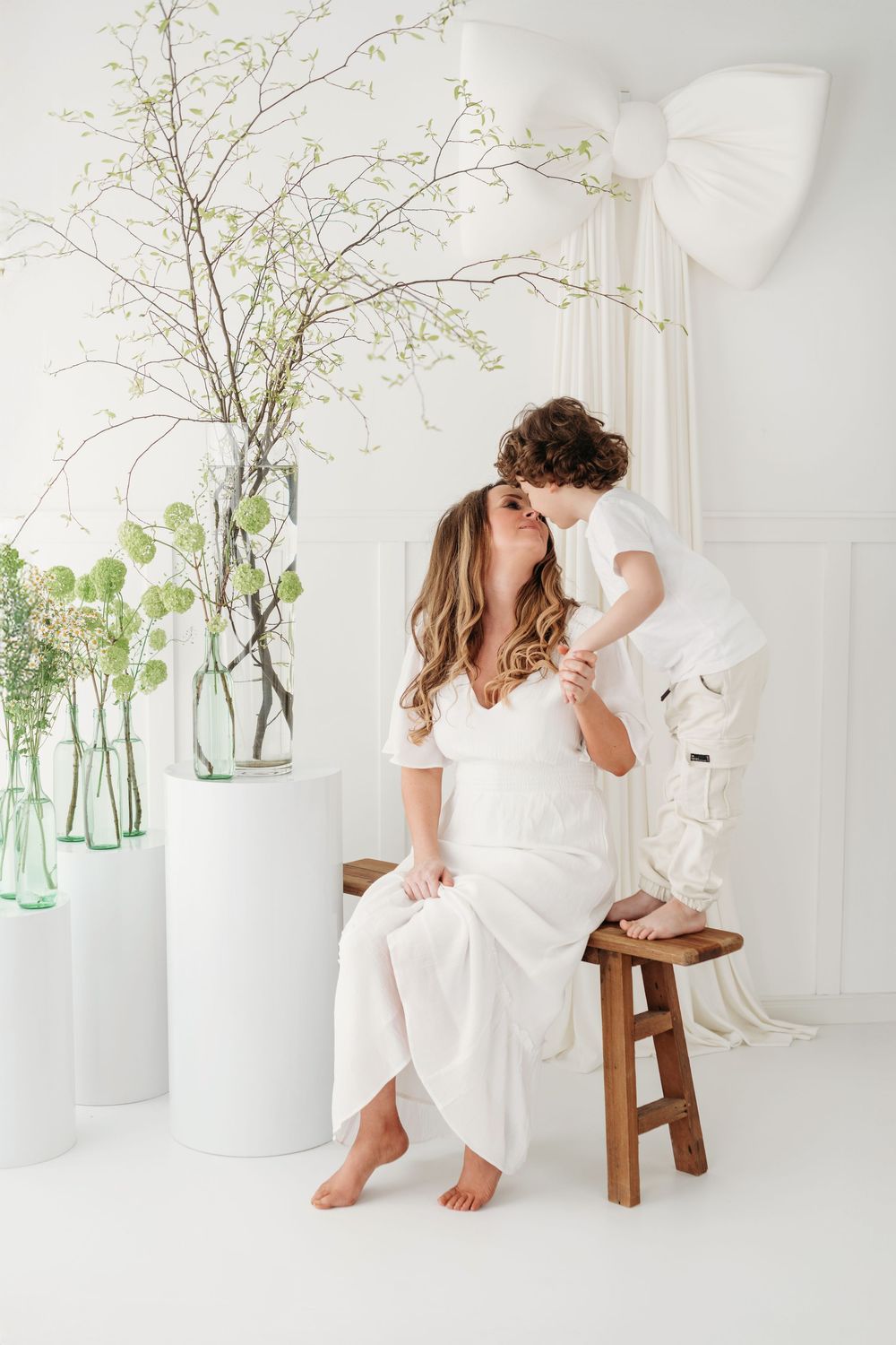 Candid lifestyle portraits showing tender moments between parent and child against a minimalist white backdrop with green accents.