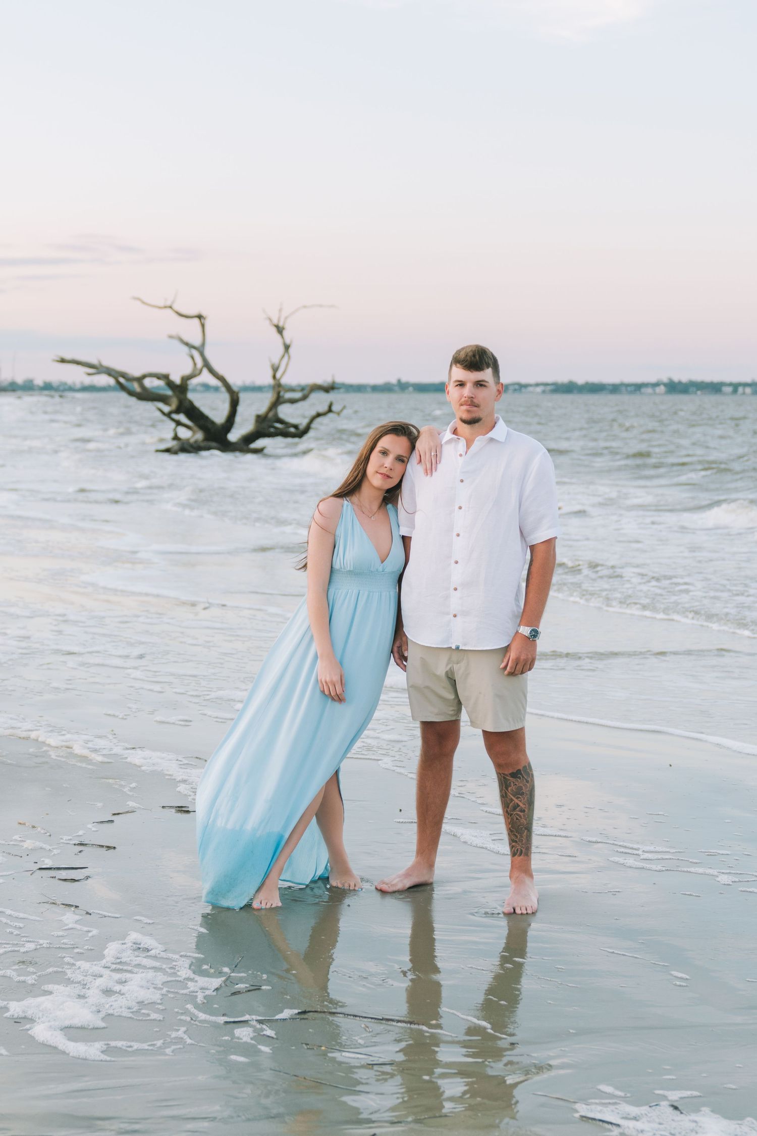Newly engaged couple during their Jekyll Island engagement photography session on driftwood beach