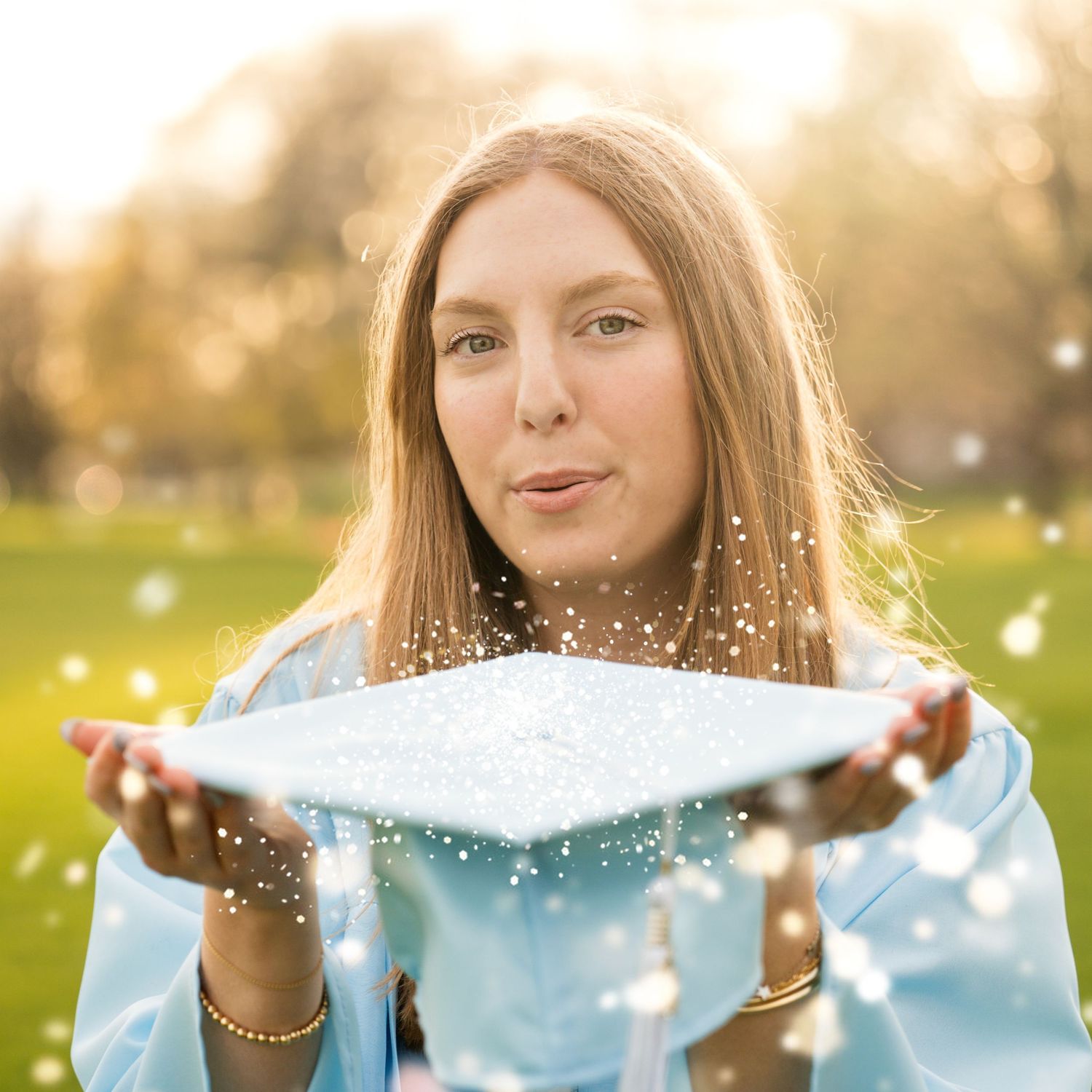 Photo of a girl blowing glitter off her cap during a cap and gown session taken by Milwaukee event photographer Rachel Dickman.