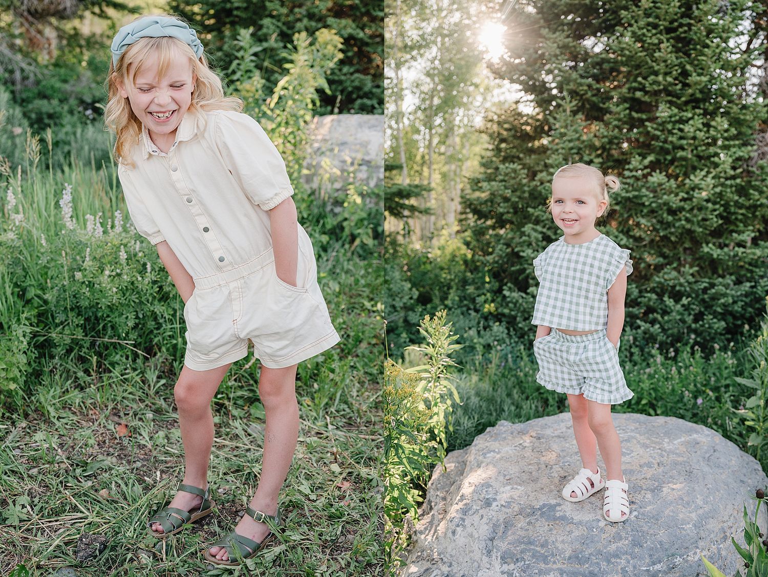 Two children wearing light colored summer outfits play outdoors among greenery and evergreen trees in natural sunlight.