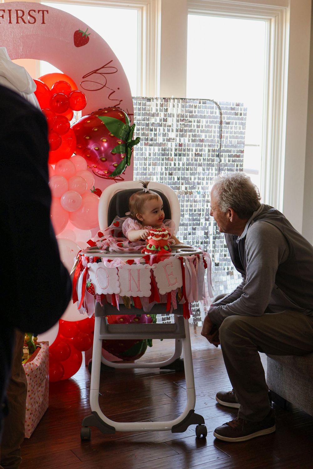 A festive high chair decorated with red and white balloons for a special celebration.