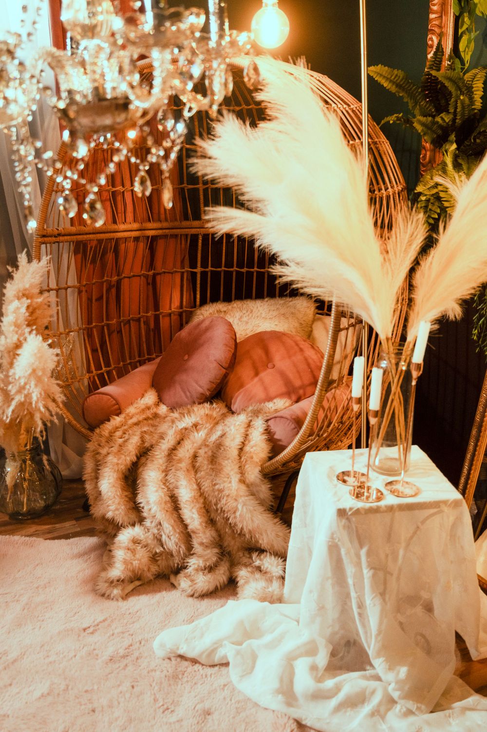 Rustic fall decor with pampas grass, wicker basket, and warm glowing light creates a cozy boho atmosphere.