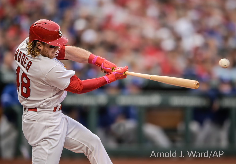 Cardinals batter swings during a baseball game, capturing the moment of contact.
