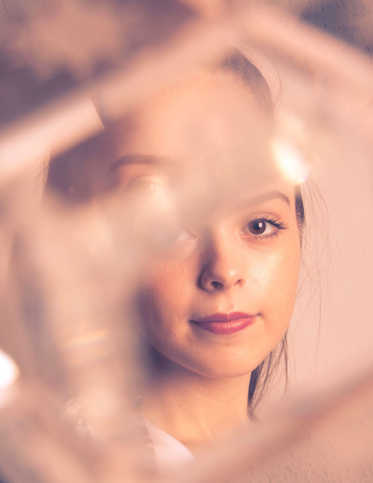 Dreamy soft focus portrait with diffused lighting and warm tones.