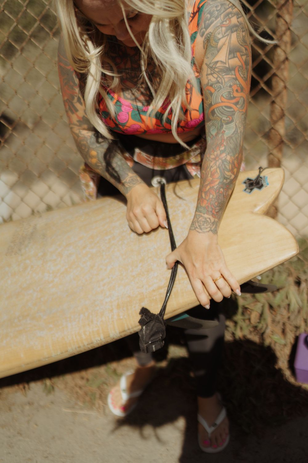 a woman waxing her surfboard