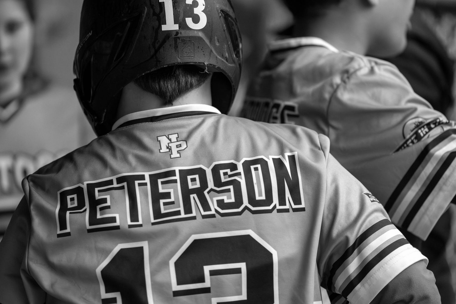 Black and white sports photo showing back of jersey with Peterson and number 13.