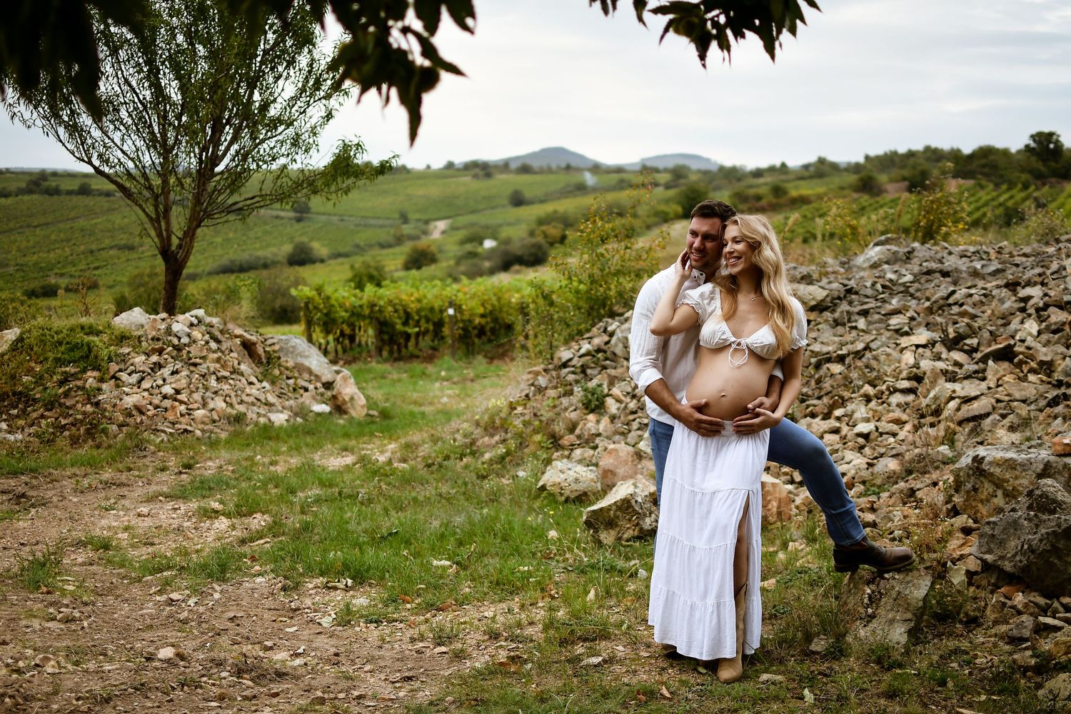 A romantic couples photoshoot in a scenic countryside setting with rocky terrain.