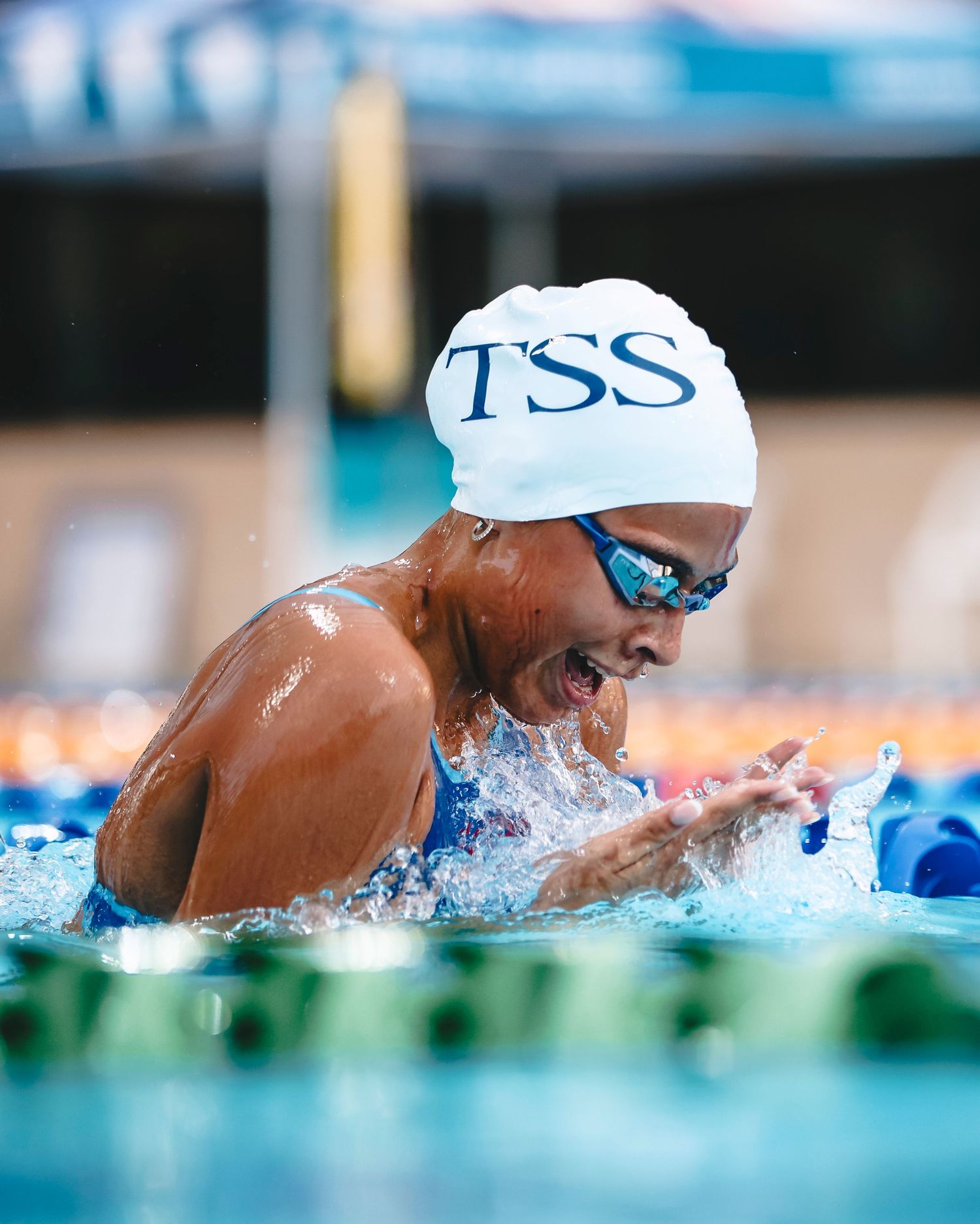 Swimmer in TSS cap performs breaststroke during competition.