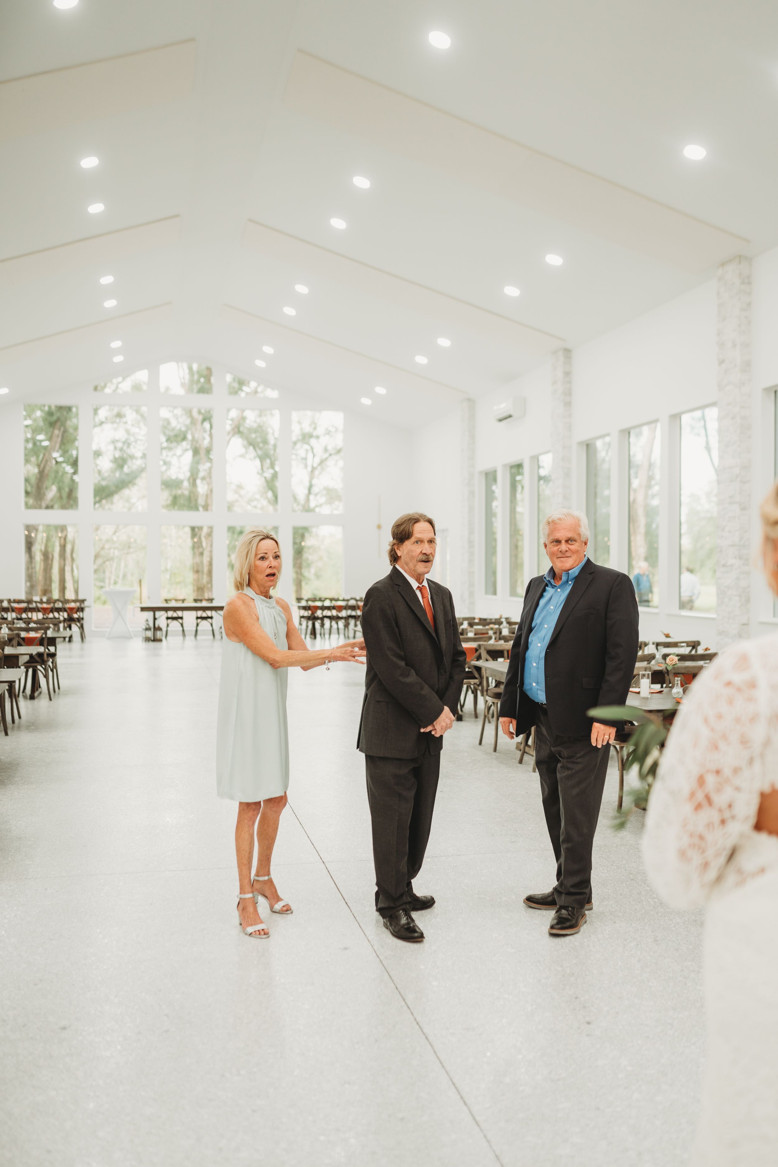 Wedding venue staff discussing details in bright modern reception hall.