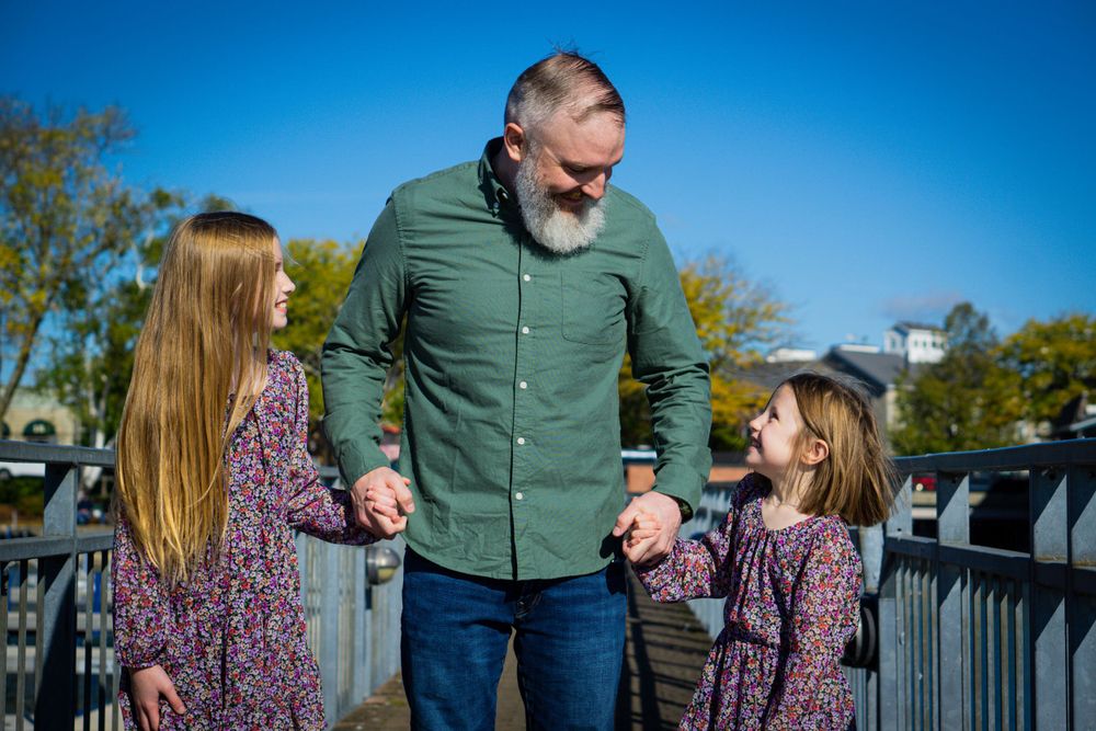 Adult and children walking together on outdoor deck enjoying sunny day.