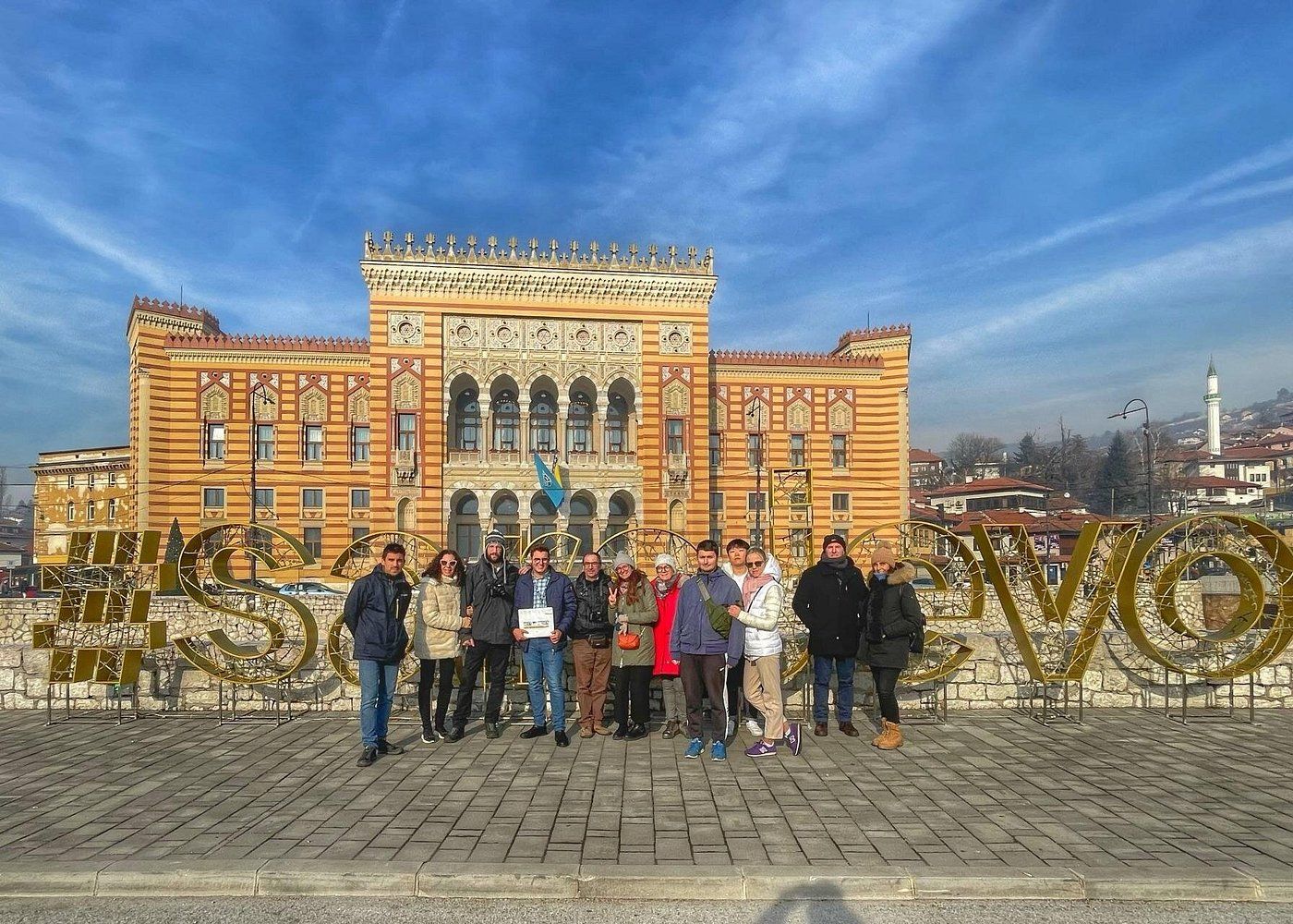 A panoramic view of Sarajevo City Hall, a historic Austro-Hungarian building with ornate architecture against a blue sky.
