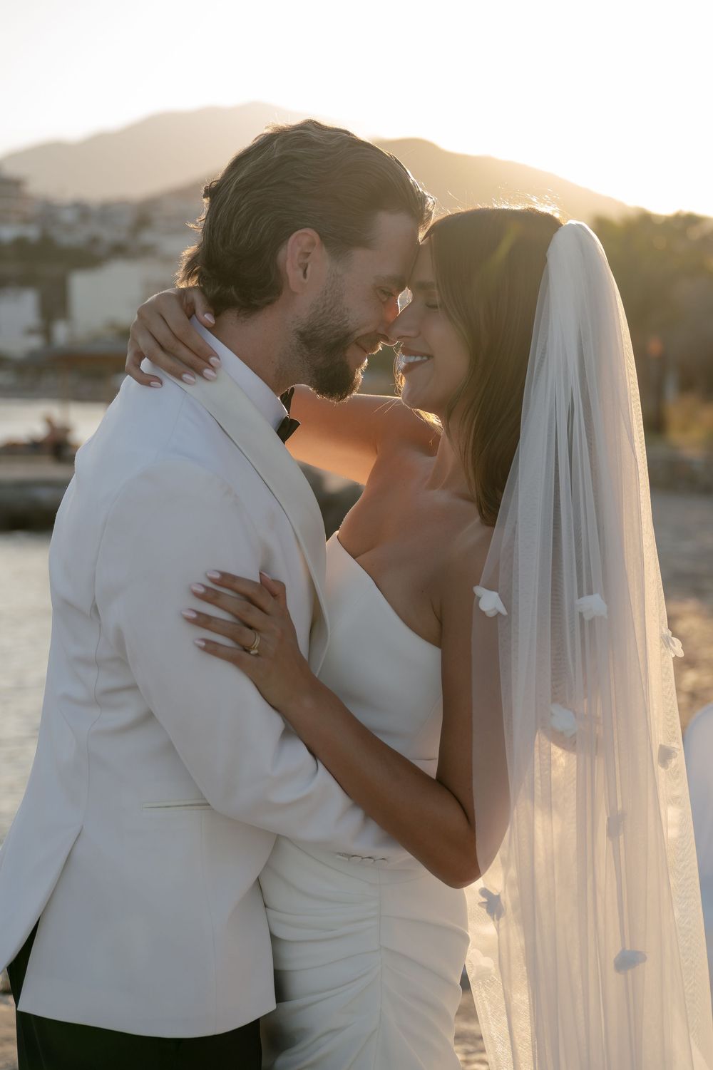 Romantic wedding couple sharing intimate kisses at sunset by the waterfront in a series of candid moments.