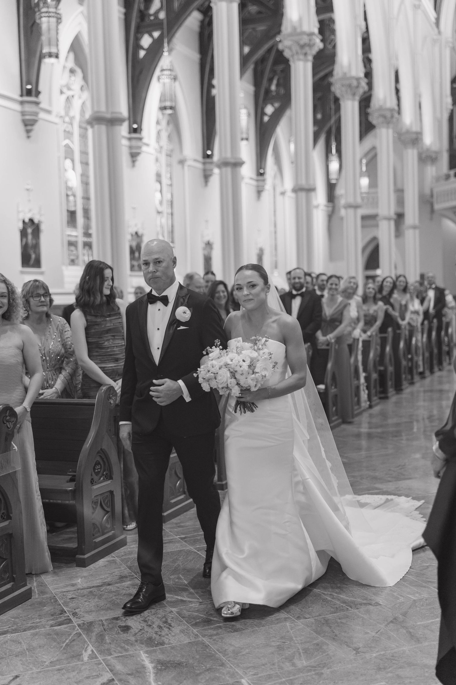 A sequence of four black and white wedding photos showing a couple dancing in an ornate church aisle.