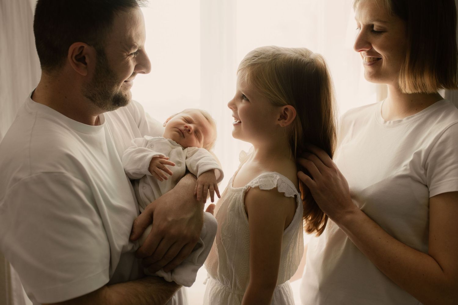 Photographe naissance à Grasse - moment tendre en famille devant une fenêtre