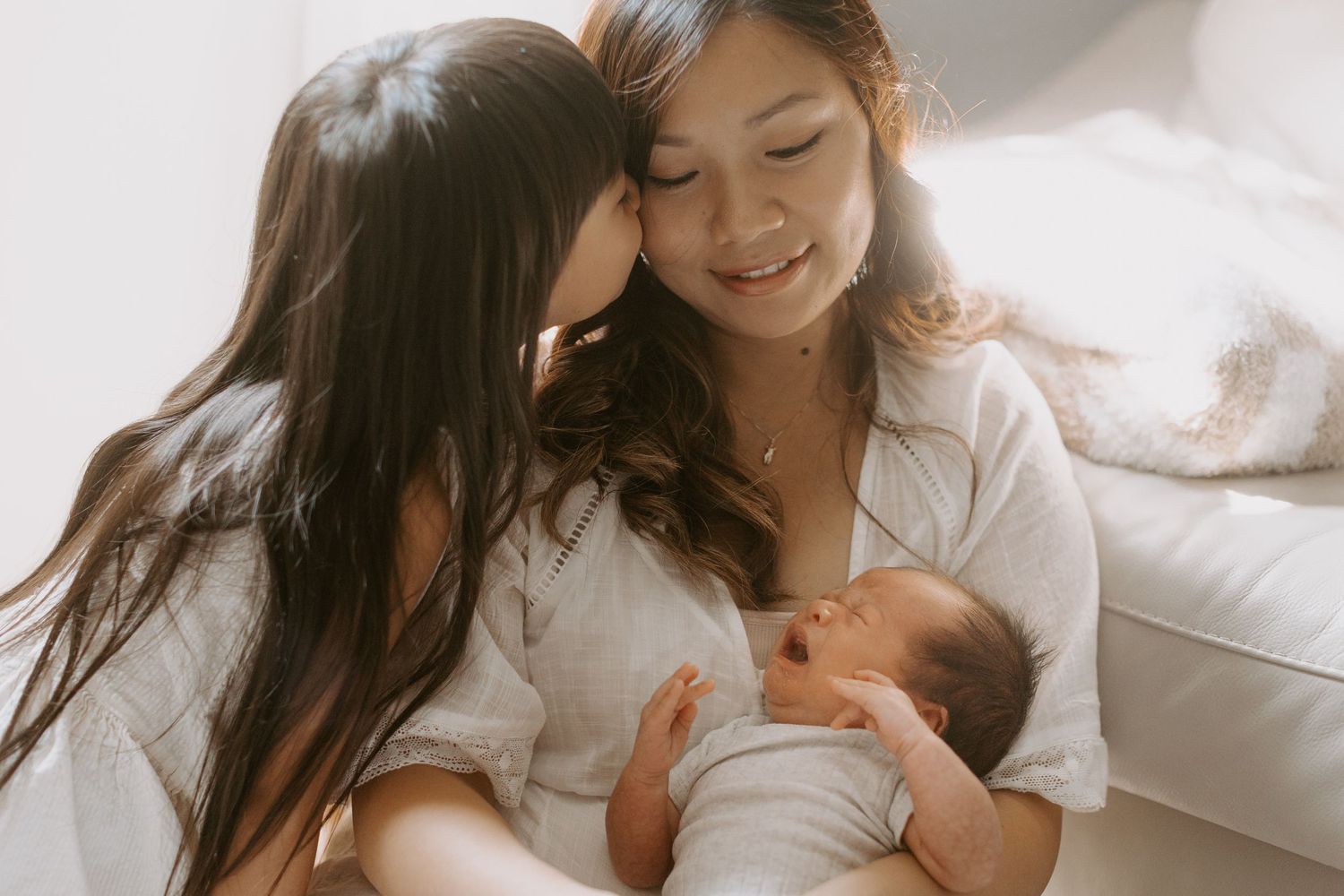 A cozy home photography session for a family with a newborn baby and dogs.