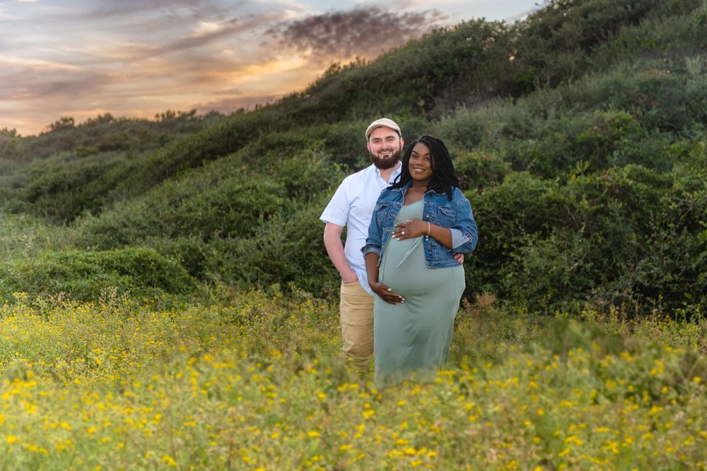 Sunset maternity photoshoot in field of yellow wildflowers.