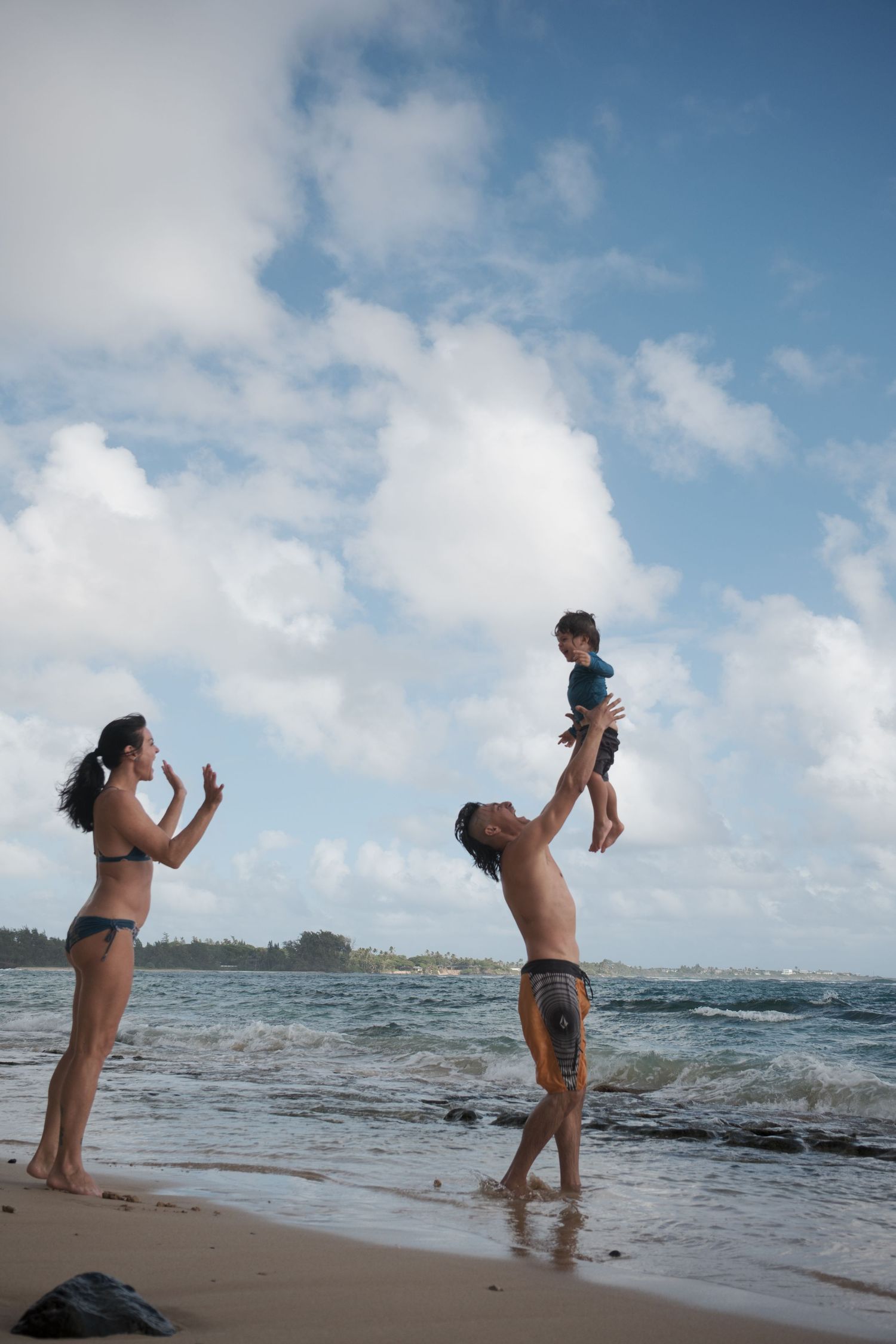 Family playing by the ocean during a North Shore Oahu family photography session on the beach.