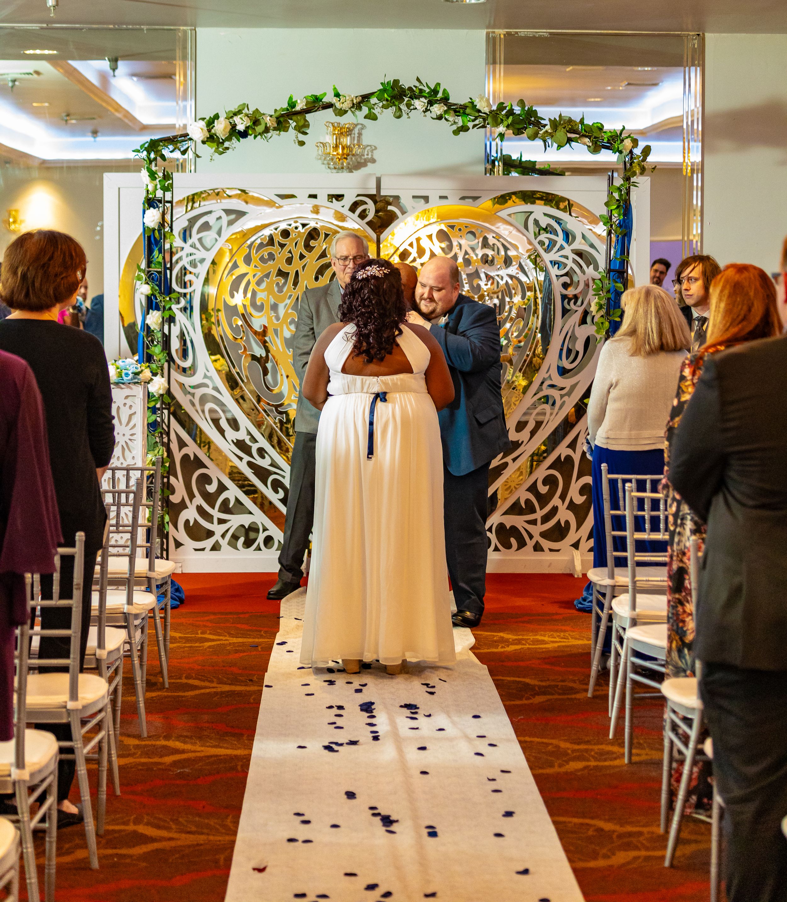 Bride walking down the aisle at a beautifully decorated indoor ceremony by Zeus Holbrook San Diego Wedding Photographer