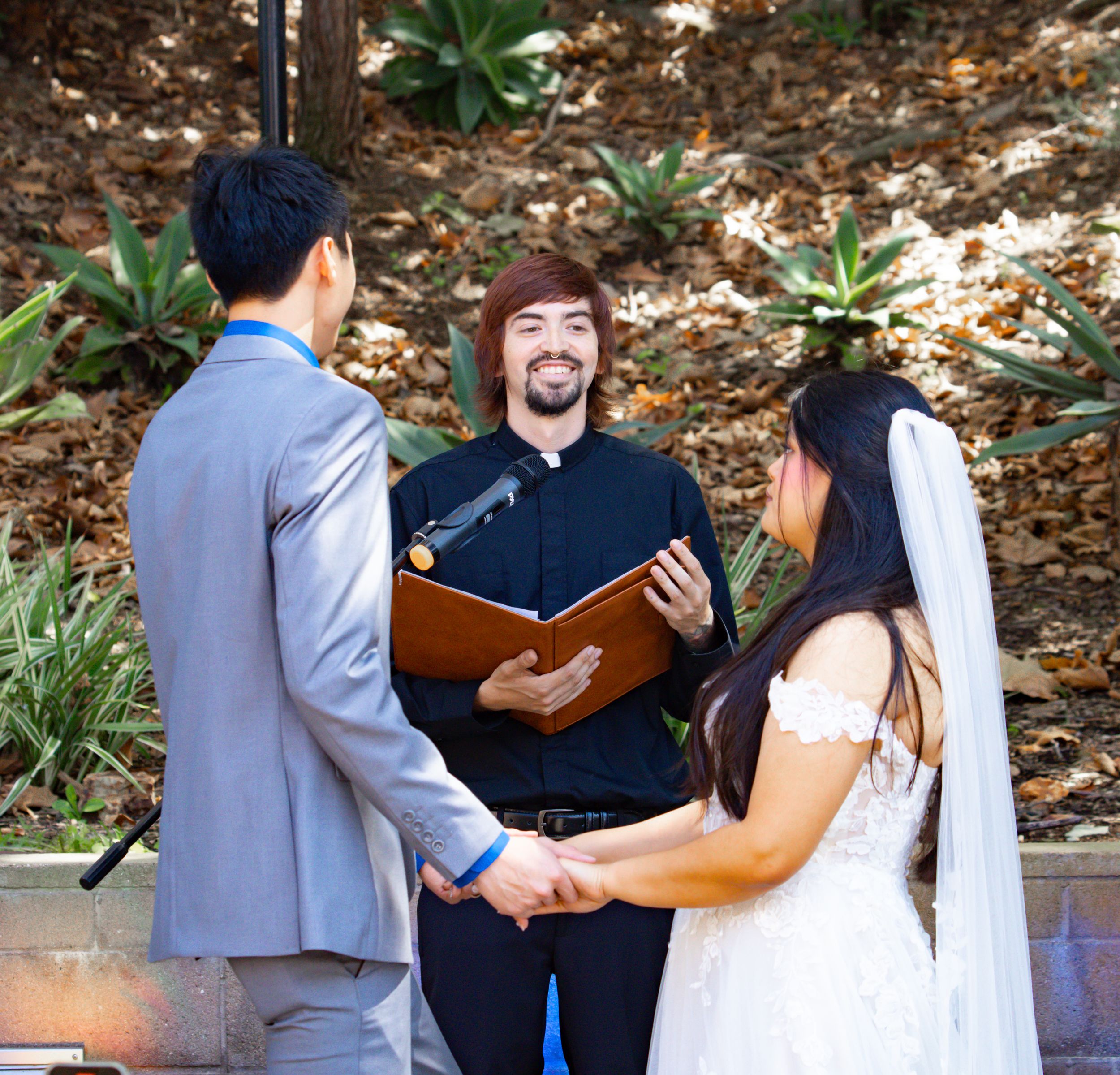 Officiant reading vows at an outdoor garden wedding ceremony photographed by Zeus Holbrook San Diego Wedding Photographer