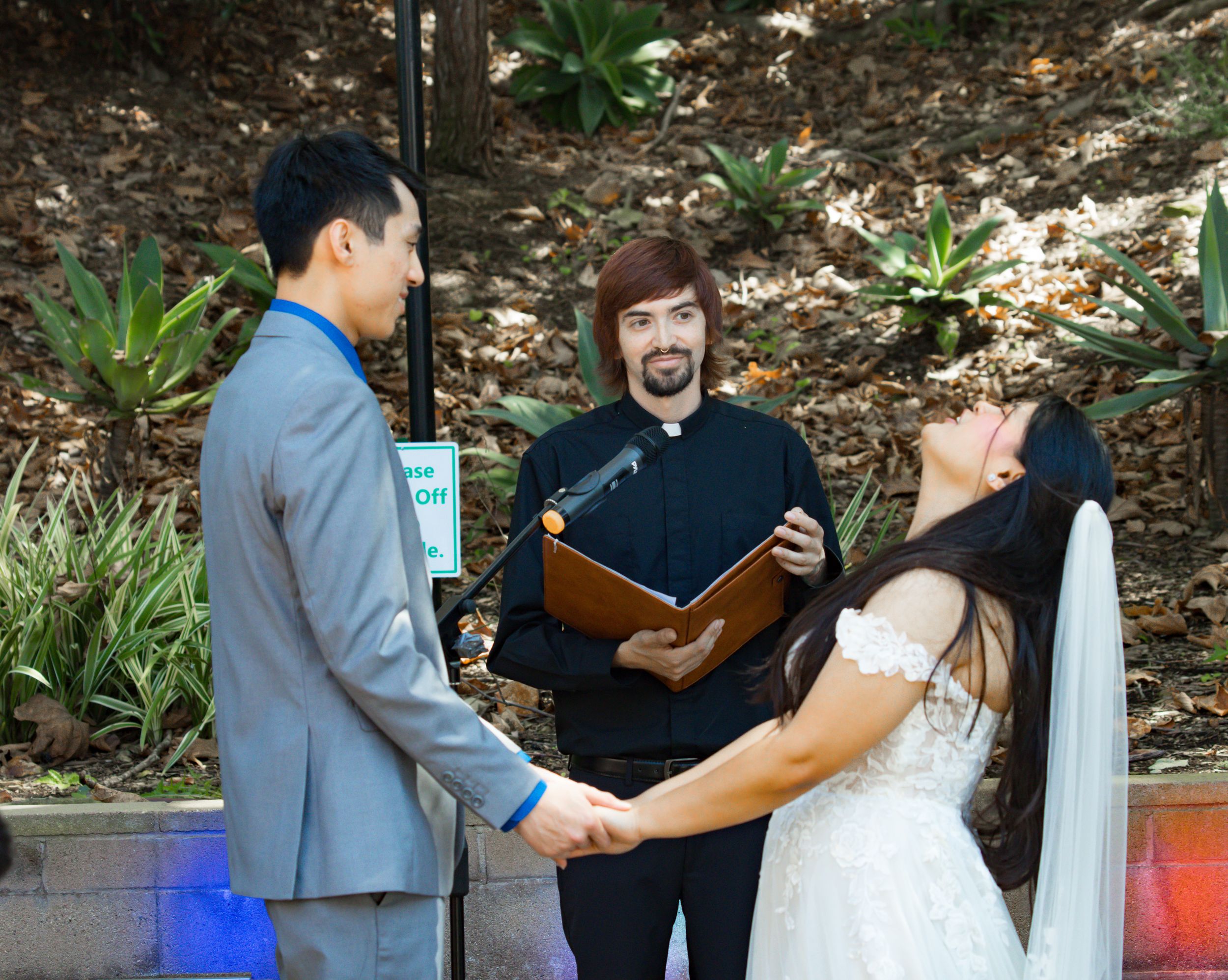 Officiant performing the wedding ceremony in a garden setting captured by Zeus Holbrook San Diego Wedding Photographer