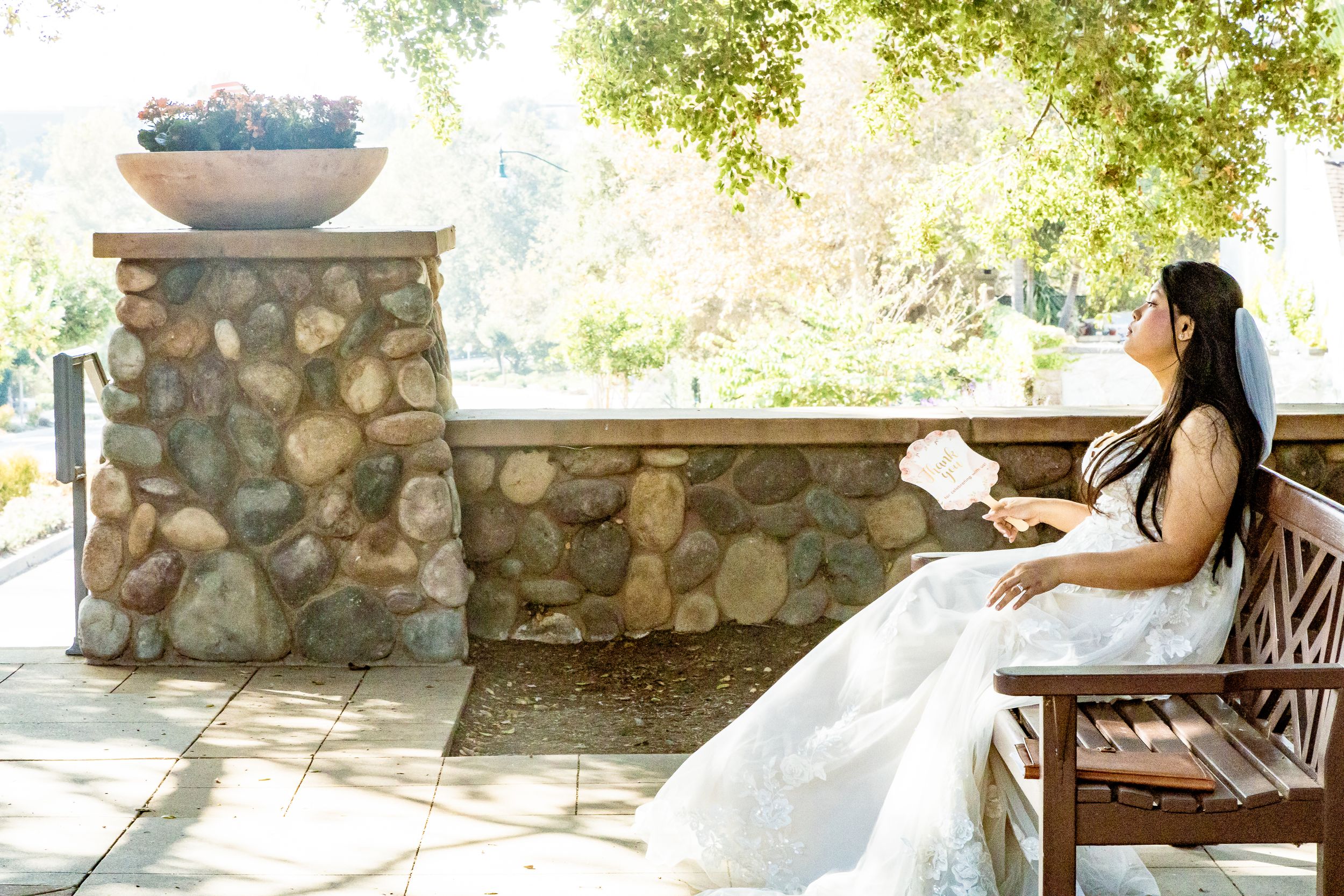 Bride sitting peacefully on a garden bench in a stone courtyard before her wedding by Zeus Holbrook San Diego Wedding Photographer