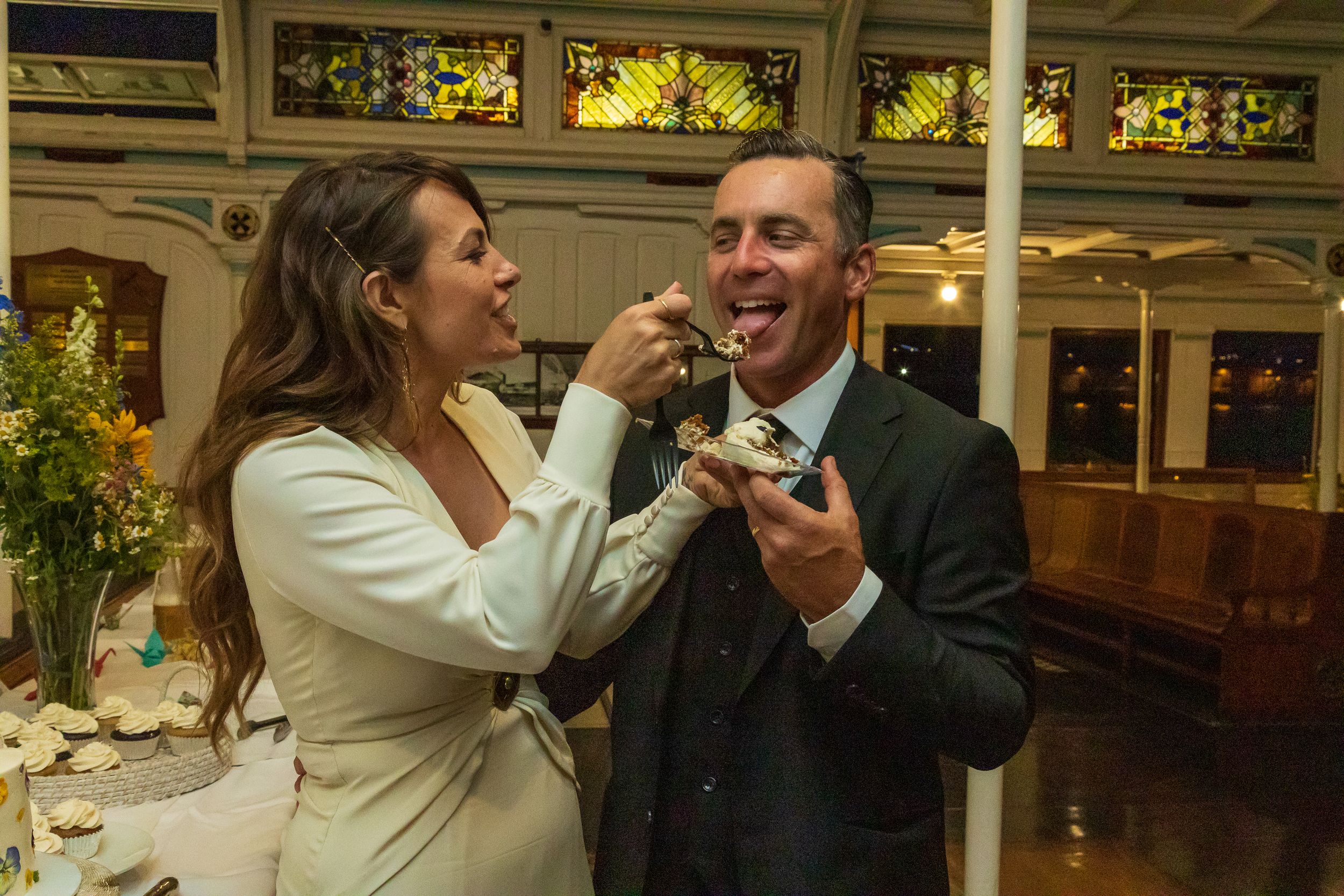Bride and groom sharing cake together at their wedding reception by Zeus Holbrook San Diego Wedding Photographer