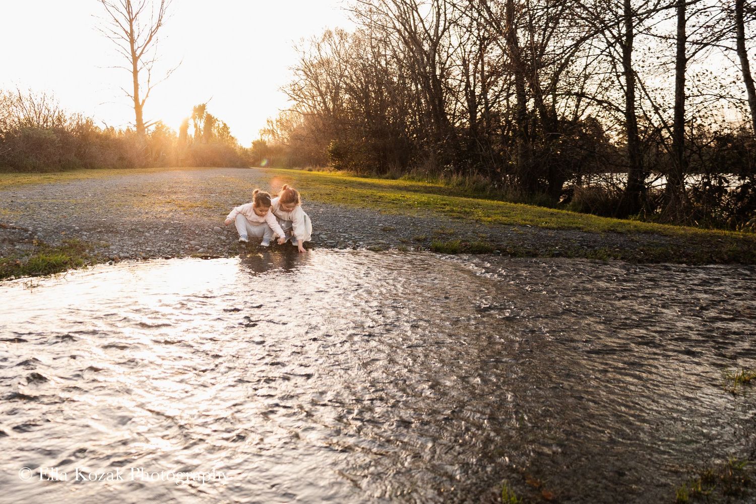 Sisters playing with the water at Roto Kōhatu Reserve during sunset