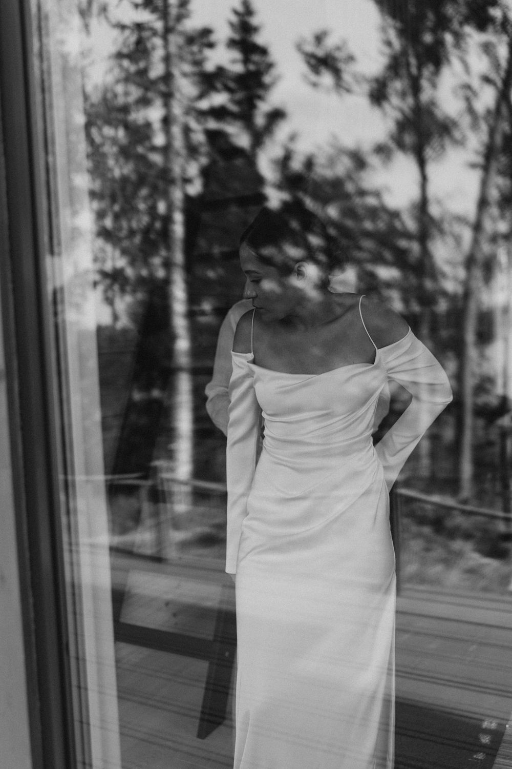 bride standing by window reflection quiet morning moment editorial wedding photography Finland