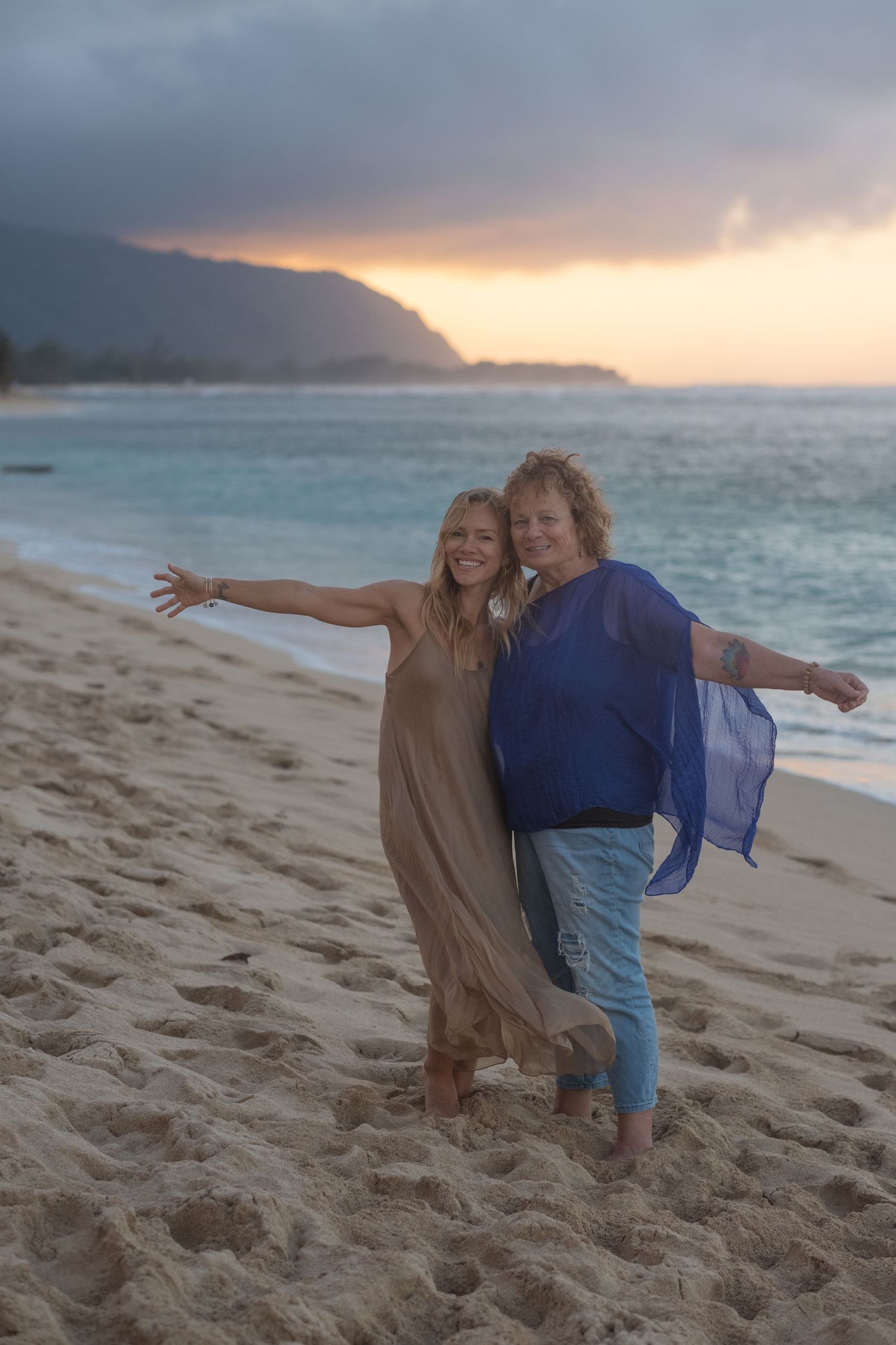 Mother and daughter sharing a joyful moment during a North Shore Oahu family photography session at sunset.