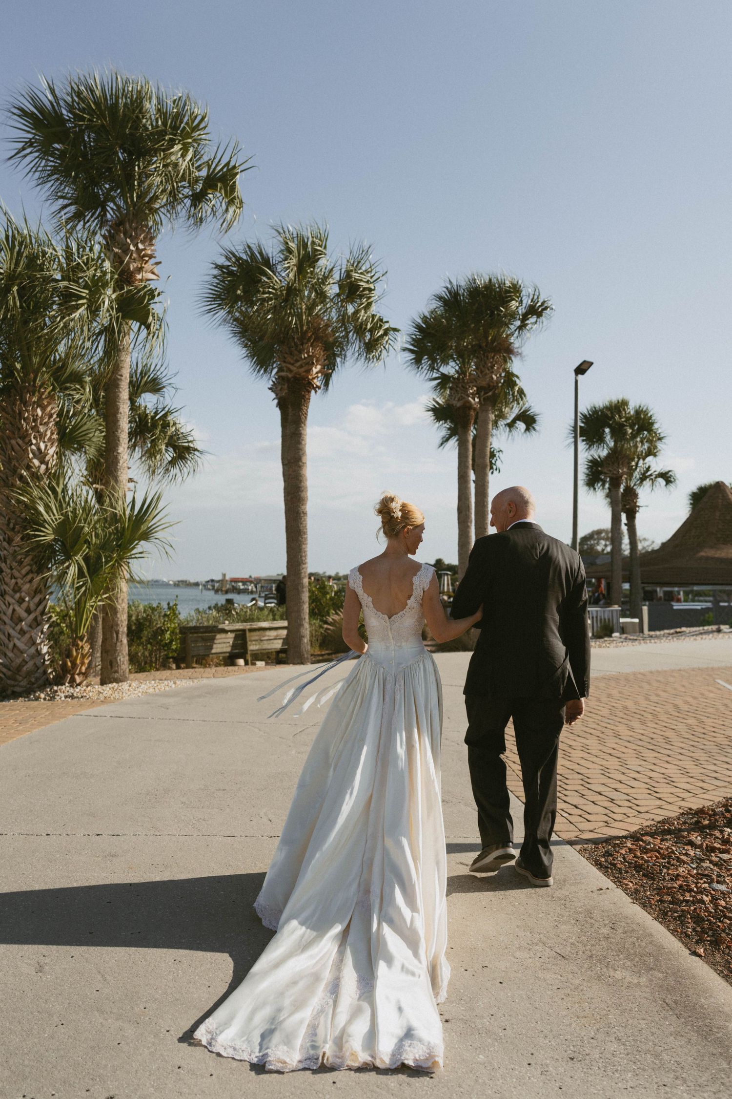 A series of intimate getting ready moments at a wedding showing the bride in a white dress being helped by others.