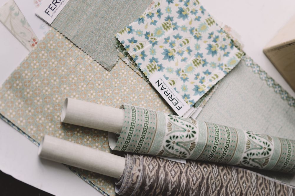 Crafting supplies including patterned papers, twine, and decorative elements arranged on a light surface.