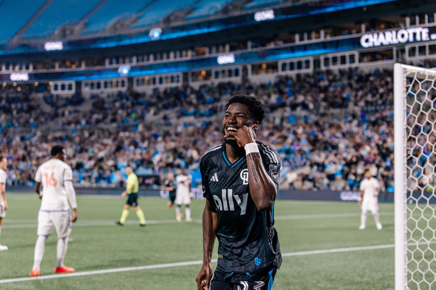 Charlotte FC player celebrating goal in black ally jersey at home stadium.