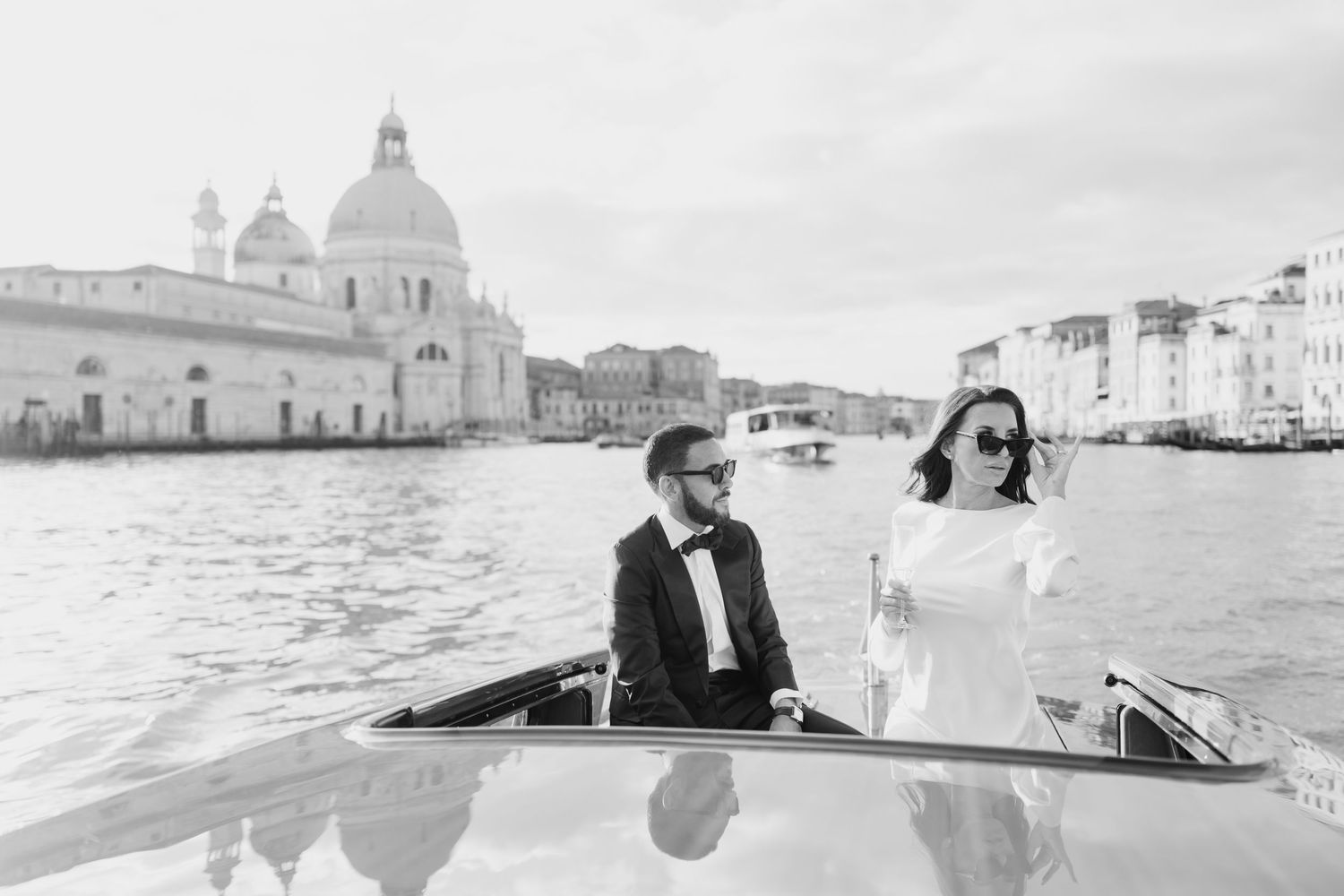 A romantic black and white wedding photo collection showing couples in Venice with gondolas and scenic architecture.