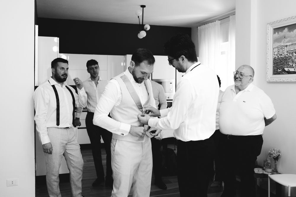 The groom getting ready with friends before the wedding in Imperia in black and white