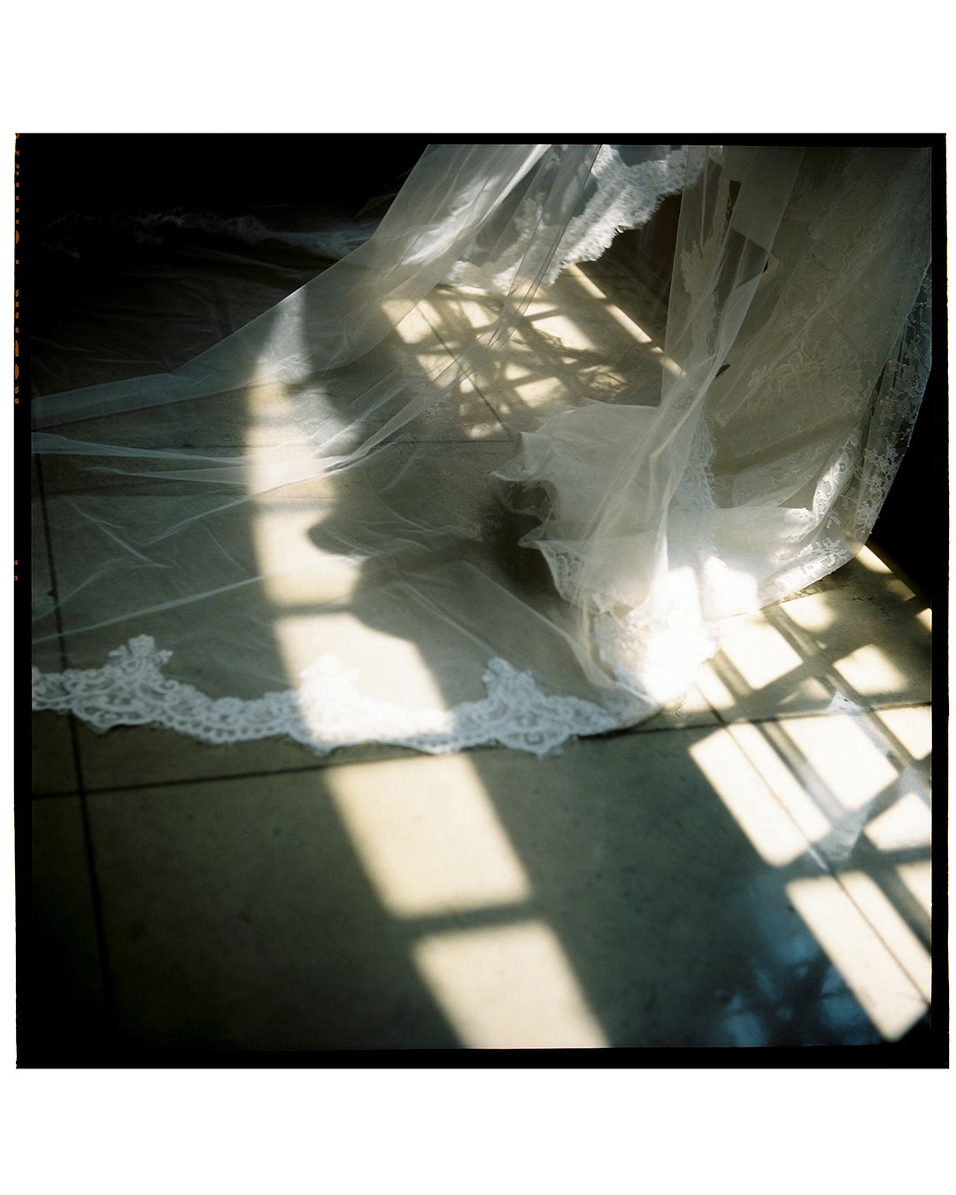Abstract patterns of light and shadow playing across white fabric on a reflective surface.
