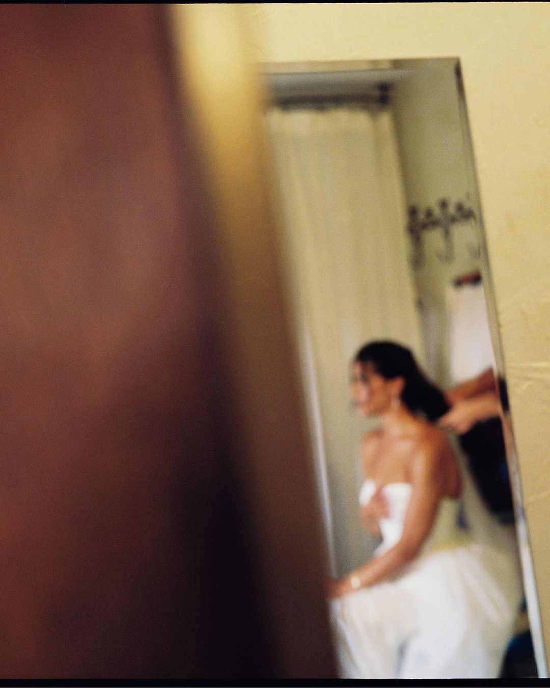 A blurry sequence of motion captures someone moving quickly through a doorway in an indoor setting.