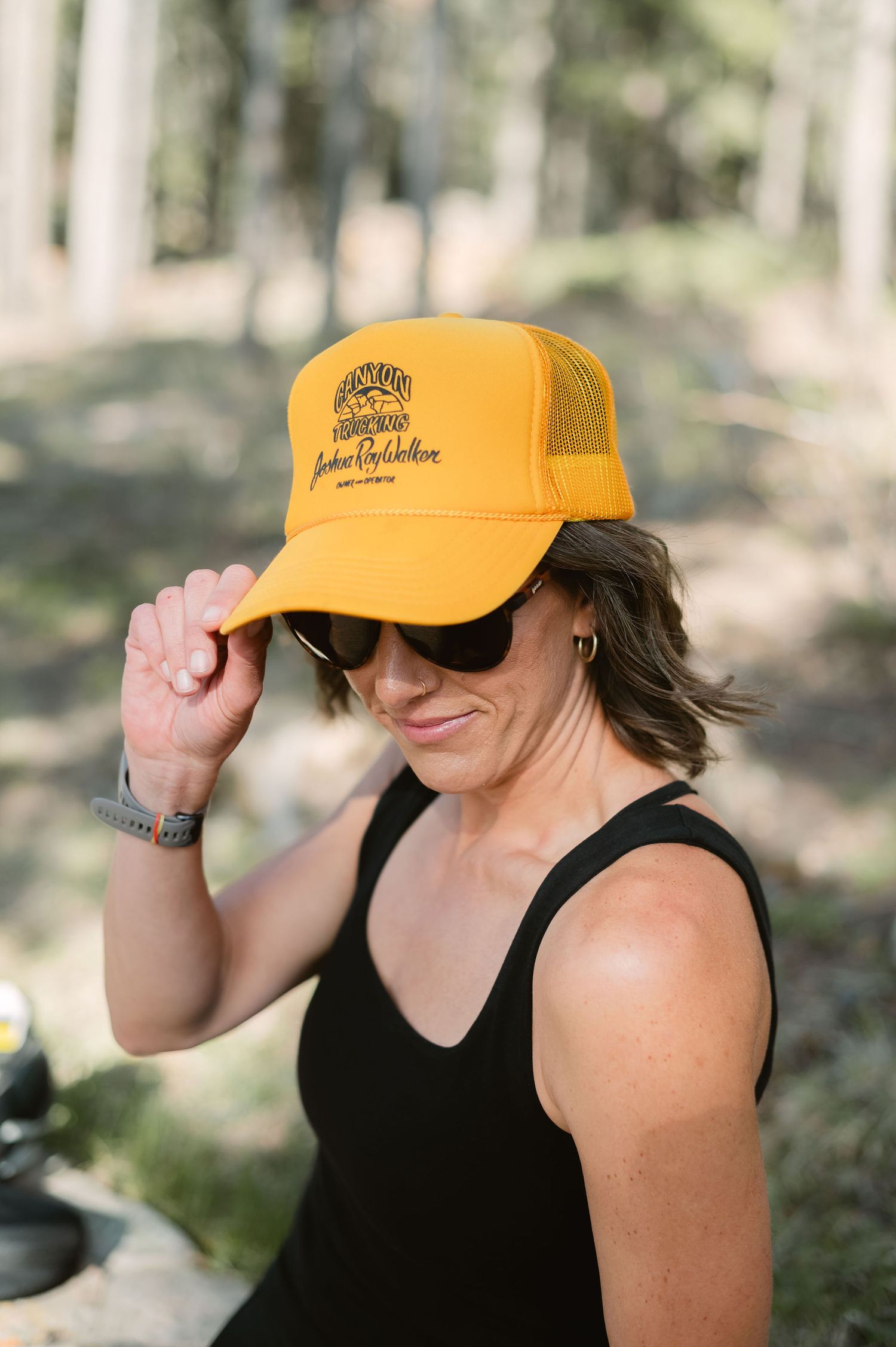Colorado photographer tipping hat in sporty outdoor setting, relaxed personal branding photo