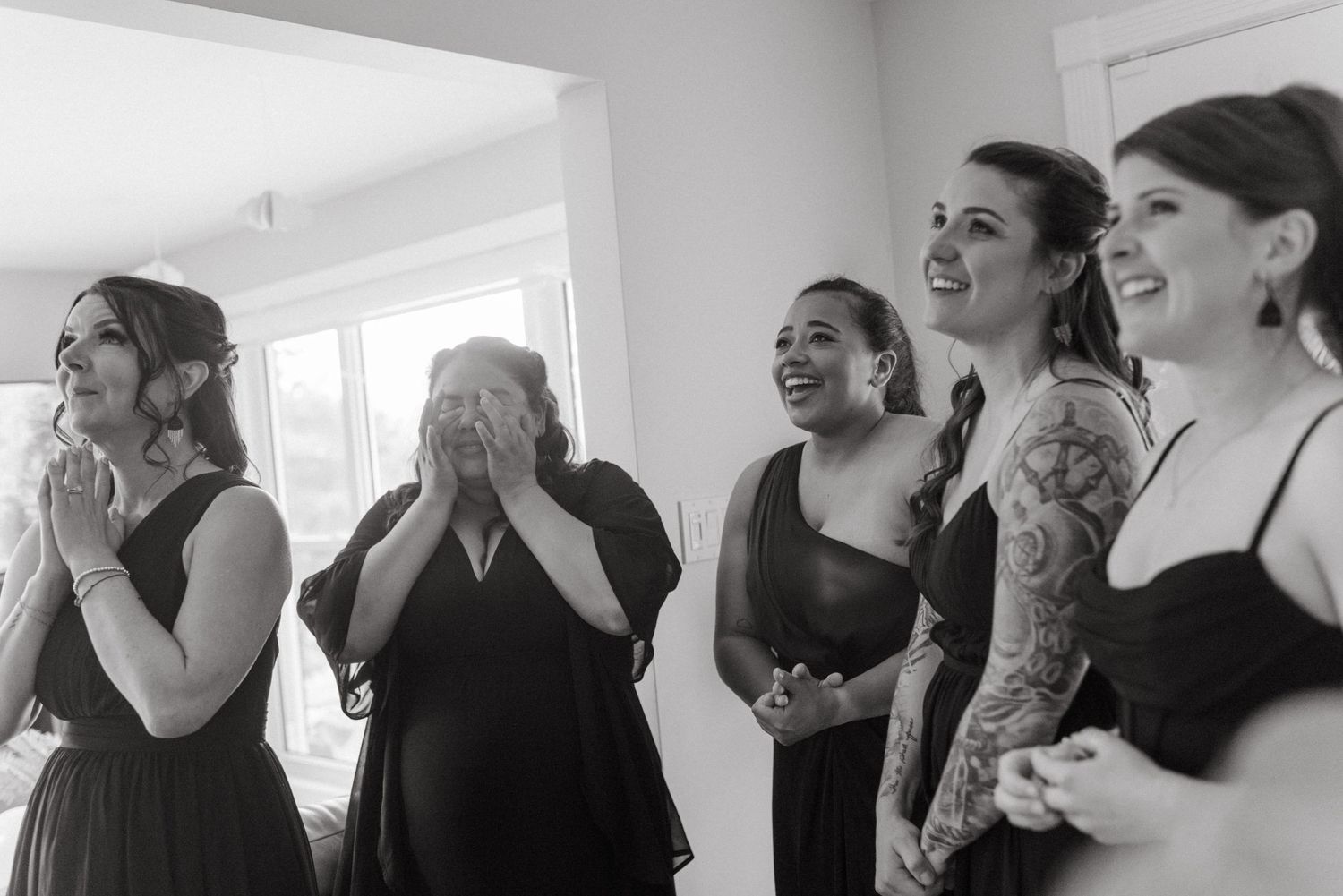 A series of black and white photos showing people laughing and expressing joy in a bright interior space.