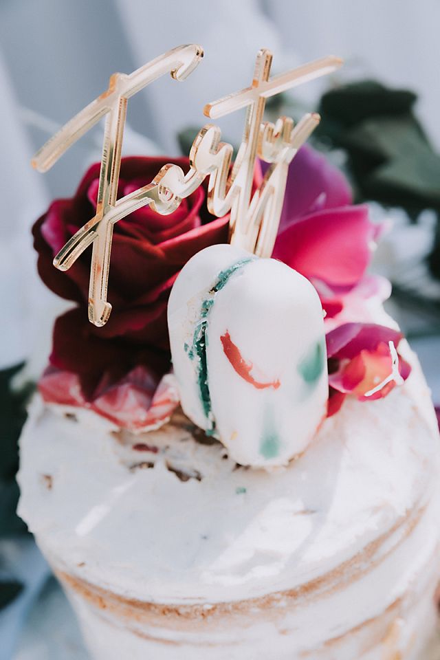 Close-up view of white cake pops decorated with pink and red roses on a white platter.