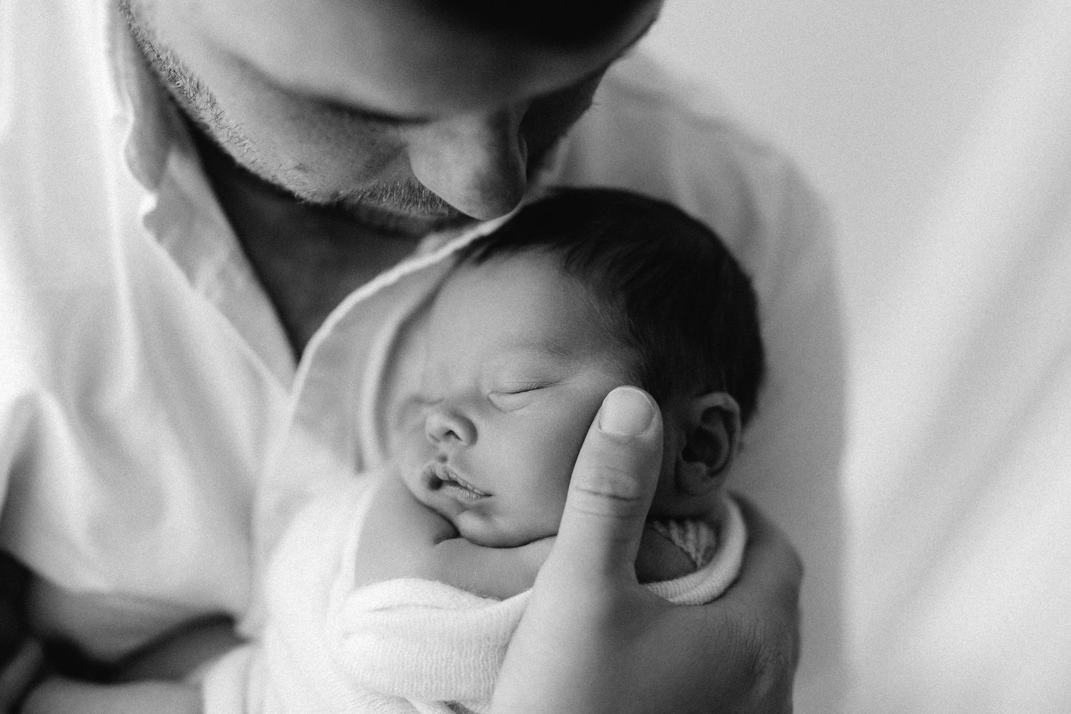 A black and white photo collage showing a baby sleeping peacefully in different positions.
