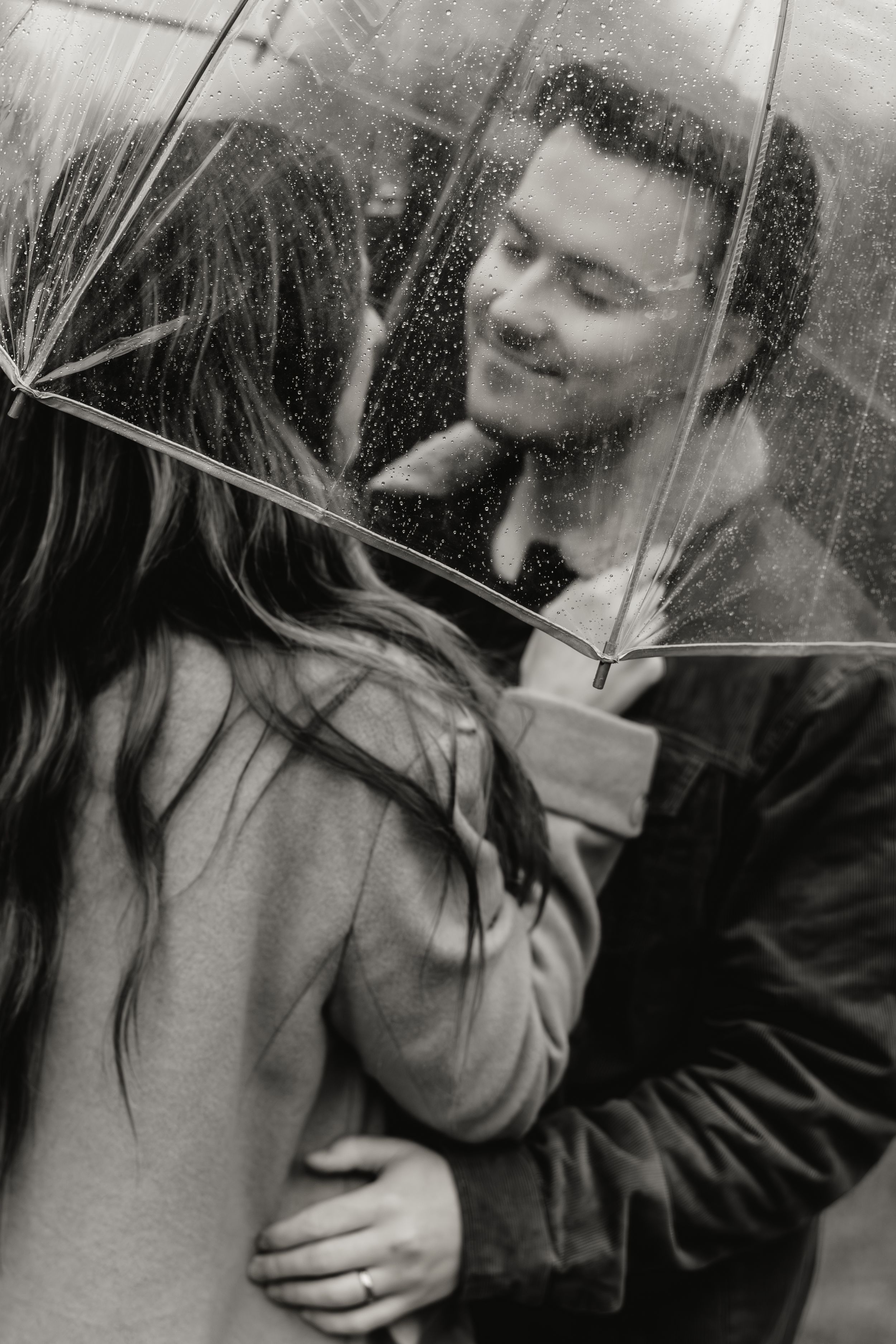 A series of black and white romantic photographs showing an intimate moment between two people in the rain.