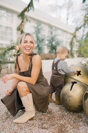 A series of fashion portraits featuring boots and a brown dress against a rustic outdoor setting with decorative bells.