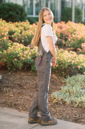 A series of photos showing small legs in gray overalls and brown boots standing in a garden with colorful flowers.