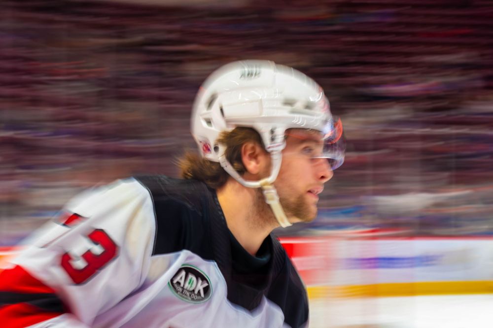 Panning shot of Utica Comets defenseman Ethan Edwards, #73, wearing a white helmet during a game against the Hershey Bears.
