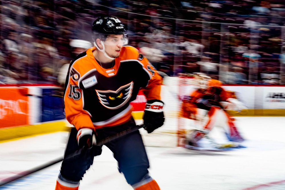 Christian Kyrou, #15, of the Lehigh Valley Phantoms, in a helmet and holding a hockey stick during a game against the Hershey Bears.