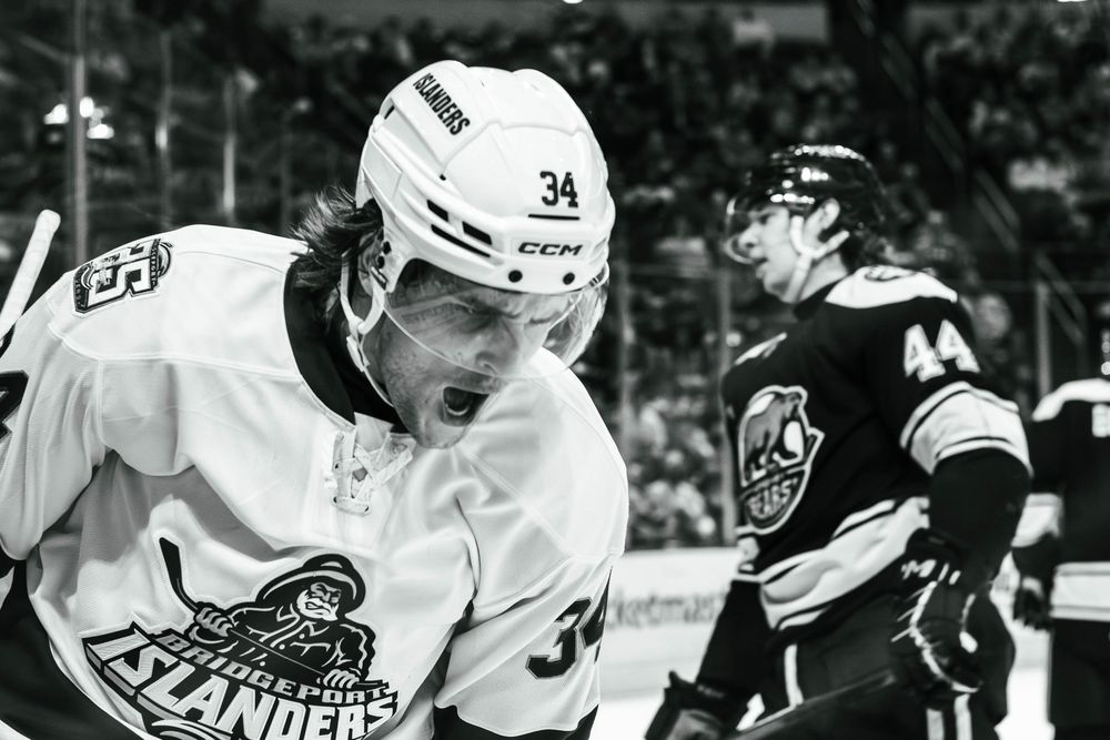 Black and white photo of Adam Beckman, #34, of the Bridgeport Islanders (now known as the Hamilton Hammers), celebrating after a goal.