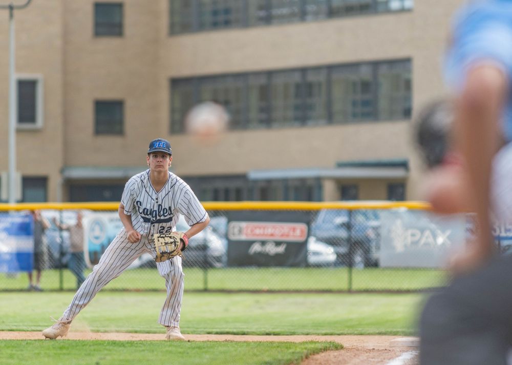 Conwell-Egan Catholic High School first baseman Jake McClain watching the pitched ball travel toward home plate.
