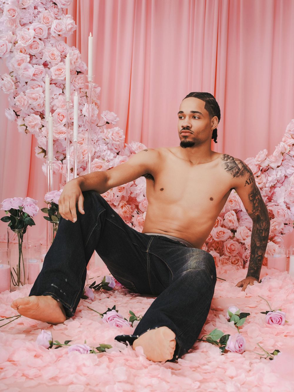 Artistic portrait series showing a shirtless man in black pants posing against a pink floral backdrop with roses.