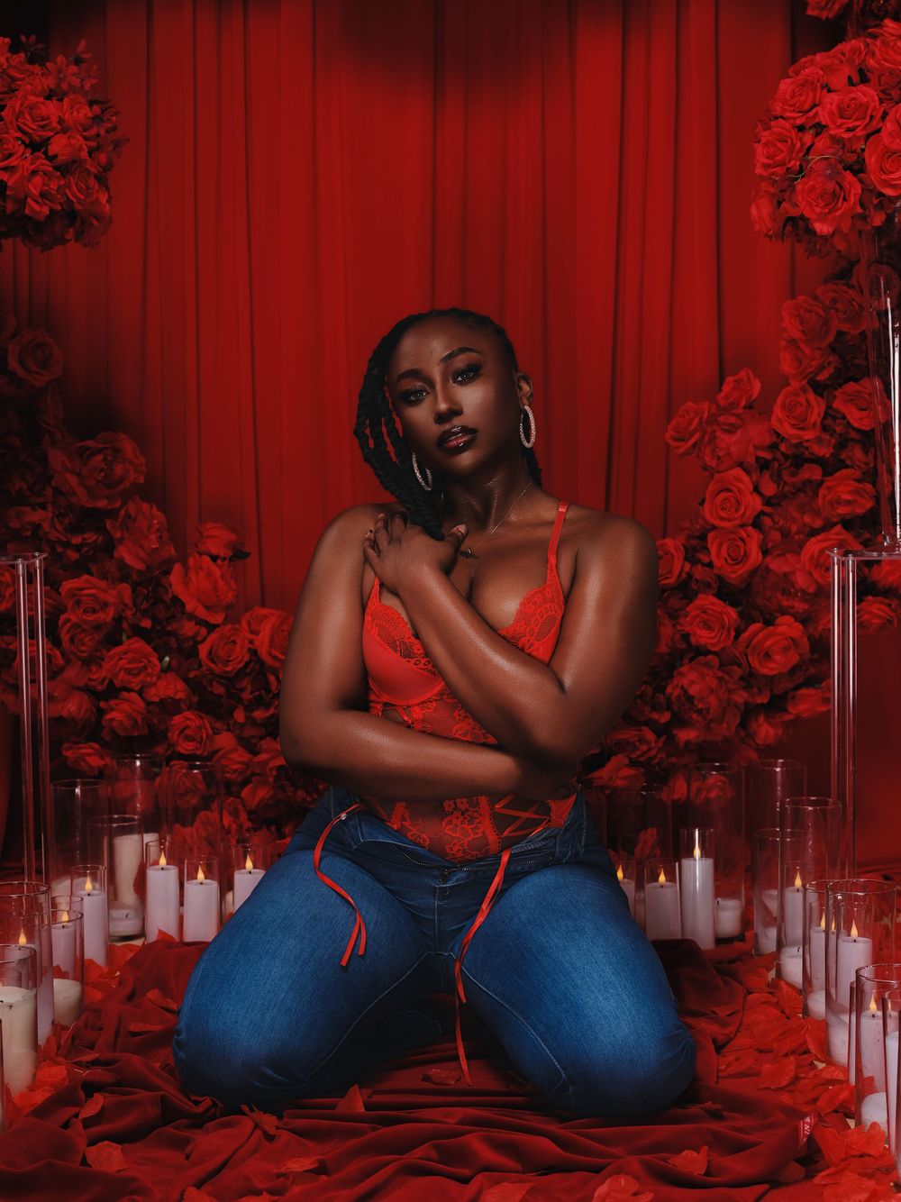 A dramatic photo series with red lighting and roses features a person in blue jeans posing against a crimson backdrop.